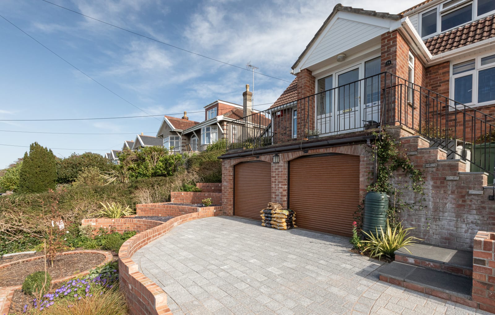 A curved driveway design with a multi-level front garden