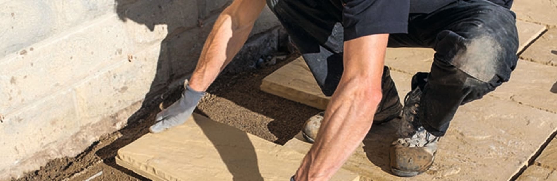 installer laying paving in a patio area