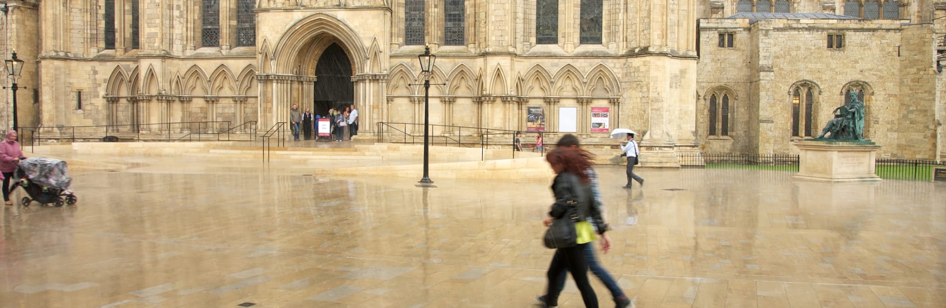 A couple walking infront of york cathedral.