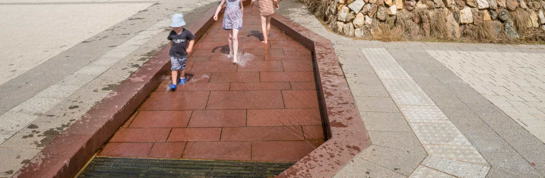 imperial red Porphyry in a water feature, children playing