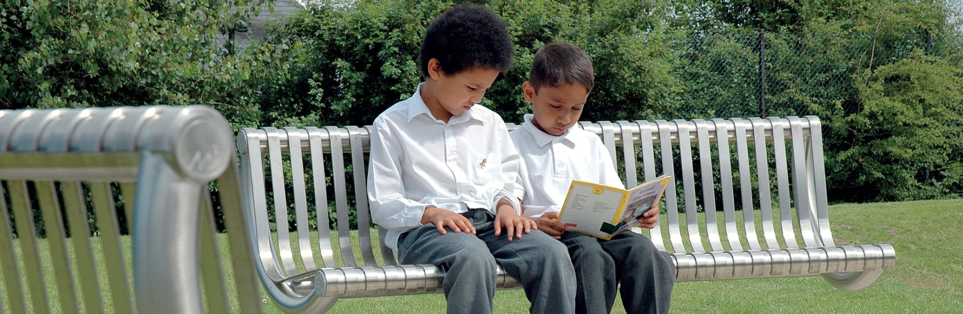 steel M3 bench with children sat reading a book