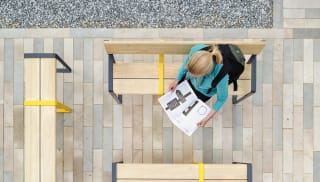 Woman reading magazine on bench