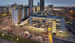 A city in the early evening, with several modern design buildings.