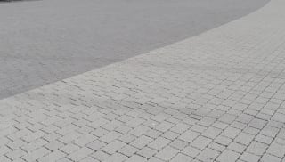 Charcoal block paving outside arena.