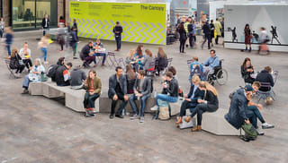 Members of the public sitting on a bench.
