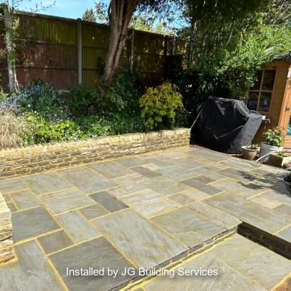 Marshalls Indian Sandstone in Grey Multi with Traditional Natural Stone Pitched Faced Walling in Silver Birch installed by a Marshalls register member.