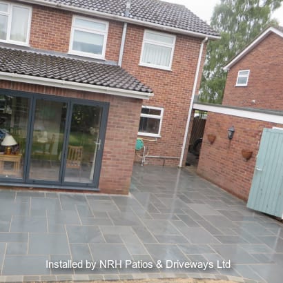 Marshalls grey paving laid in front of a red house.