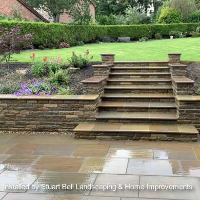 Marshalls Flamed Narias with Sawn Versuro steps and Natural Stone walling in autumn bronze installed by a Marshalls register member.