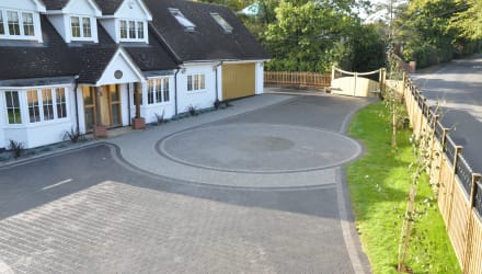 A large circular driveway design using grey paving