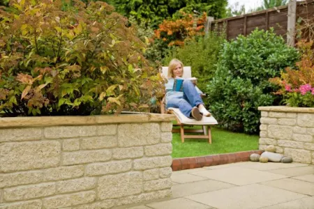 A woman sat on a chair reading a book in a garden