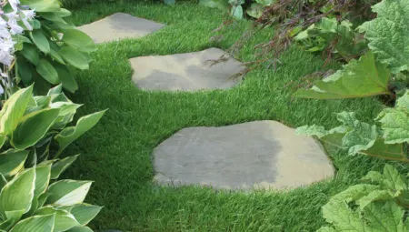 Grey stepping stones placed on top of grass.