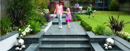 Woman and child holding hands in a garden