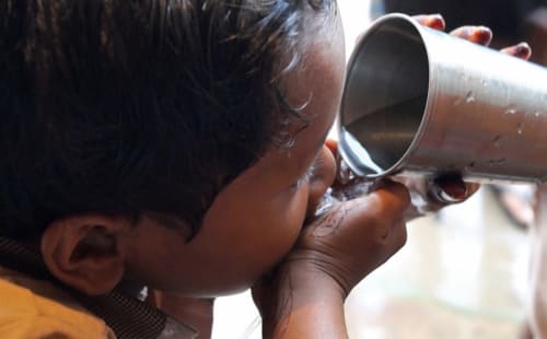 child drinking water from cup