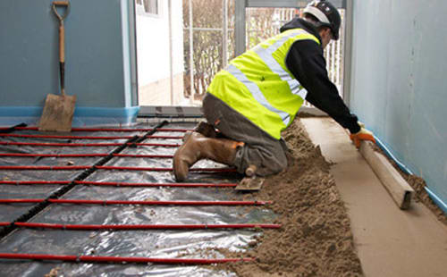 builder laying screed on housing floor.