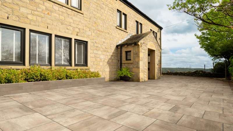 Infinia Patio in Bronze Sandstone laid infront of a house