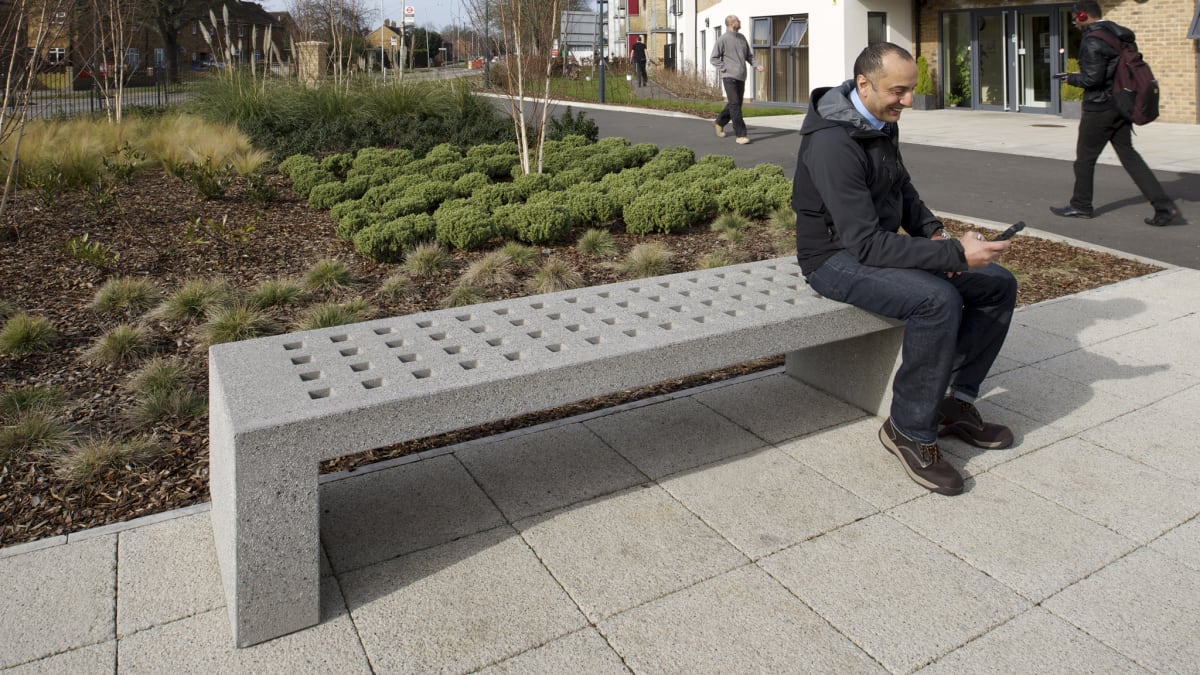 man sat on grey mayo bench outside