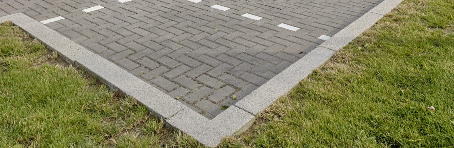 Light grey kerb used in car park in front of office building.