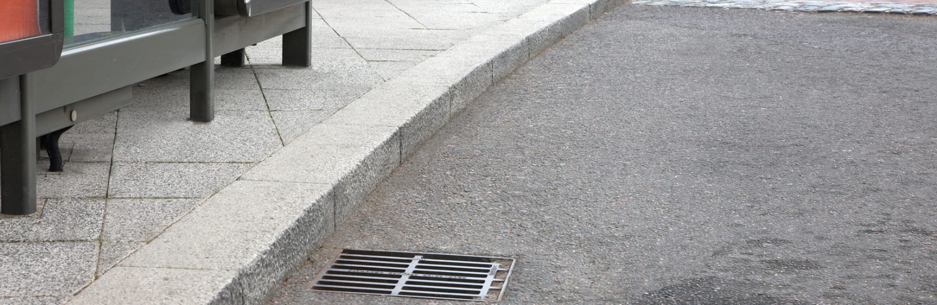 Grey conservation kerb next to a bus stop.