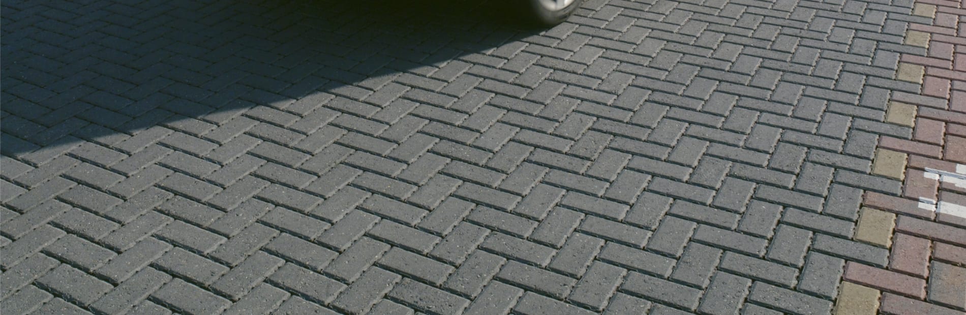 Black car driving in a car park.