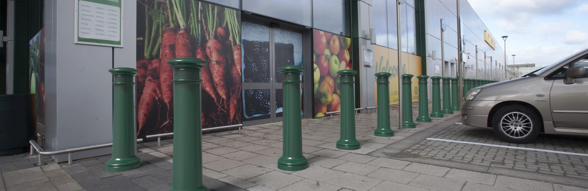 Green PAS 170 bollards outside a Morrisons store