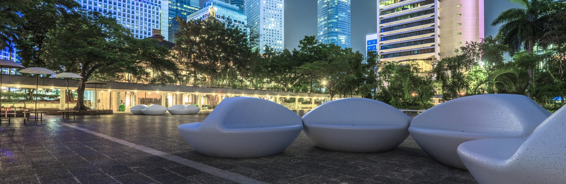 Universo benches seen at night against a city backdrop