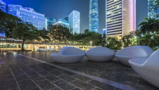 Universo benches seen at night against a city backdrop