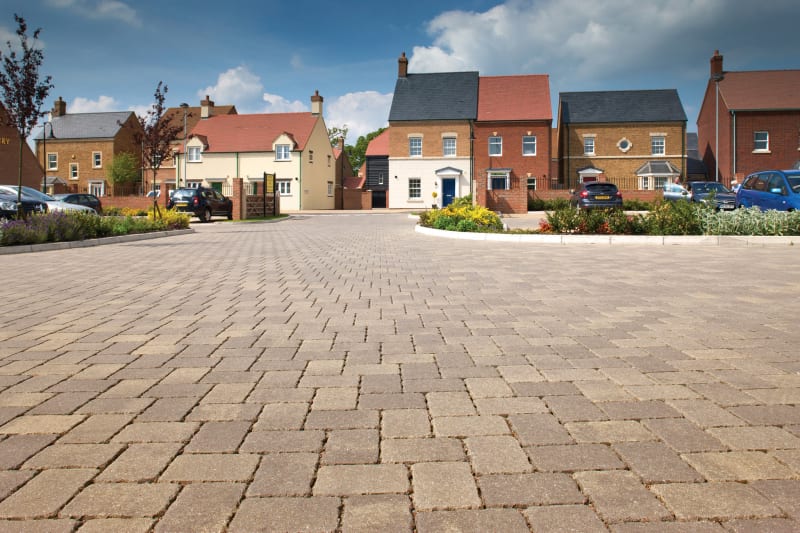 Buff block paving used in the road in front of modern housing.