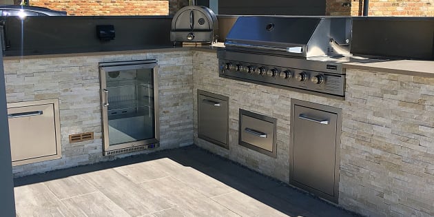 Outdoor kitchen featuring pizza oven and barbeque