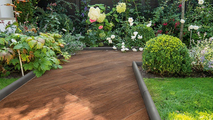 A wooden garden path with plants on either side