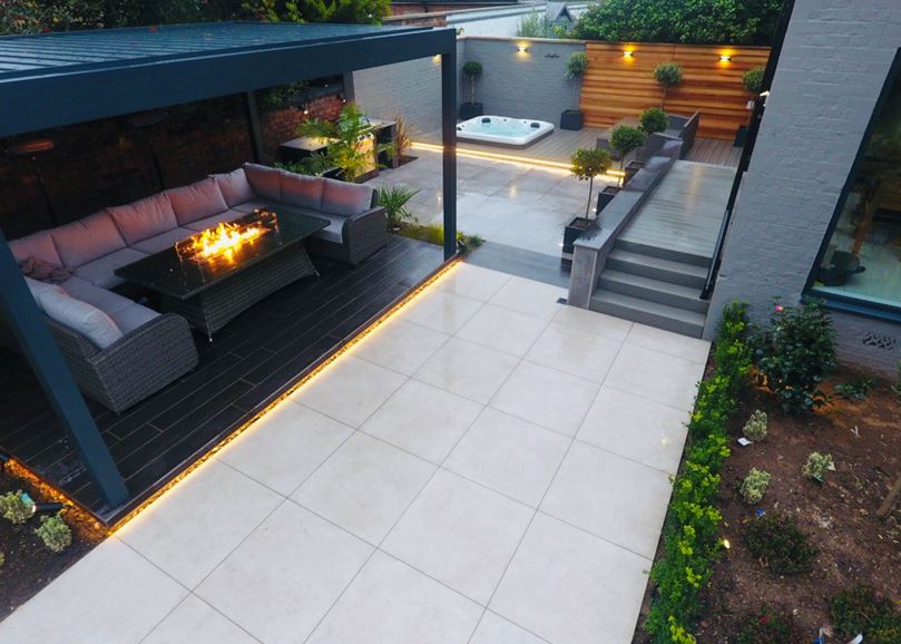 A grey awning over patio seating and a firepit