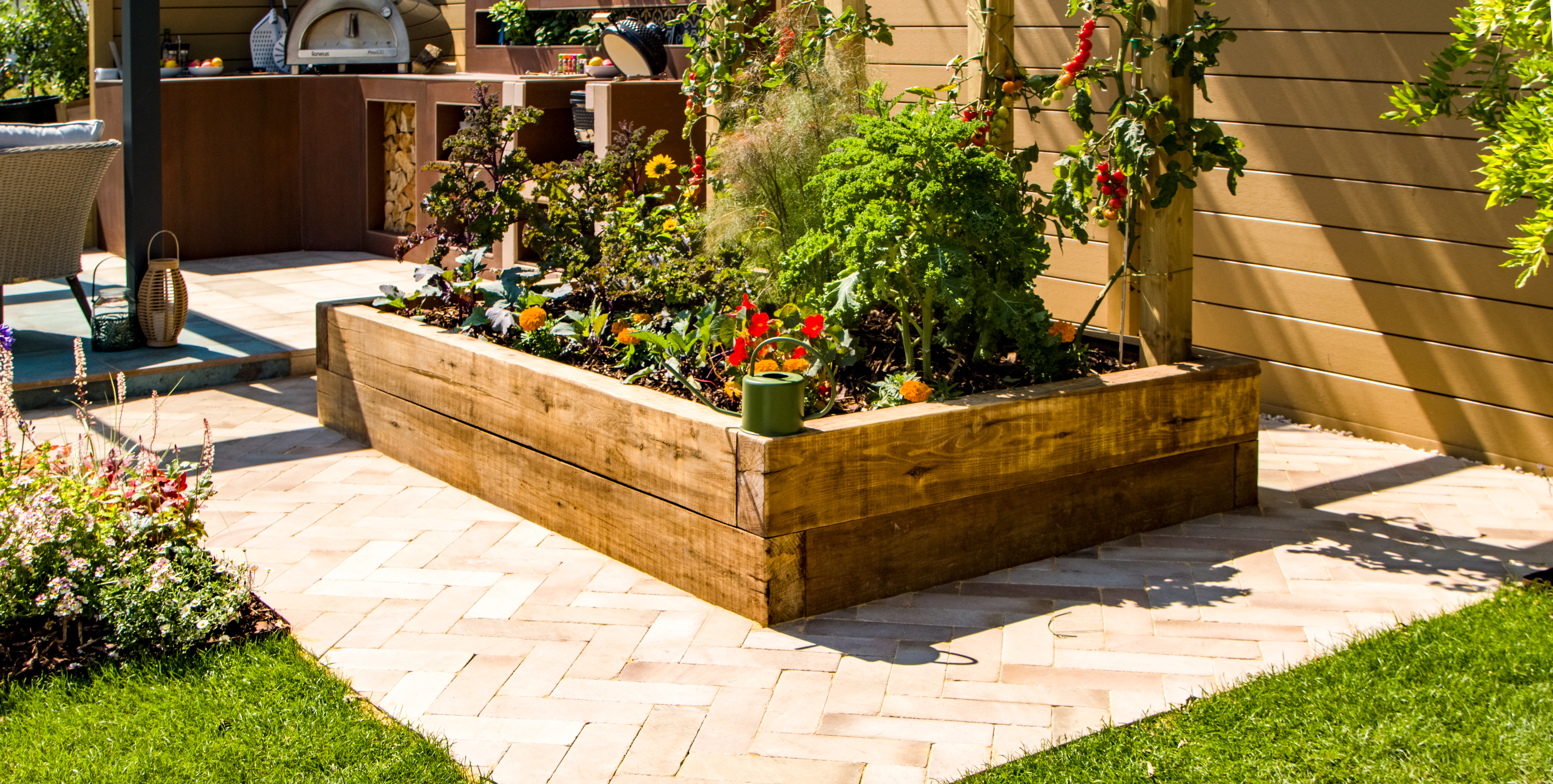 A raised bed surrounded by light paving slabs