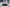 child sat on horseshoe shaped bench outside shops