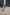 2 people walking on light red block paving in a housing estate.